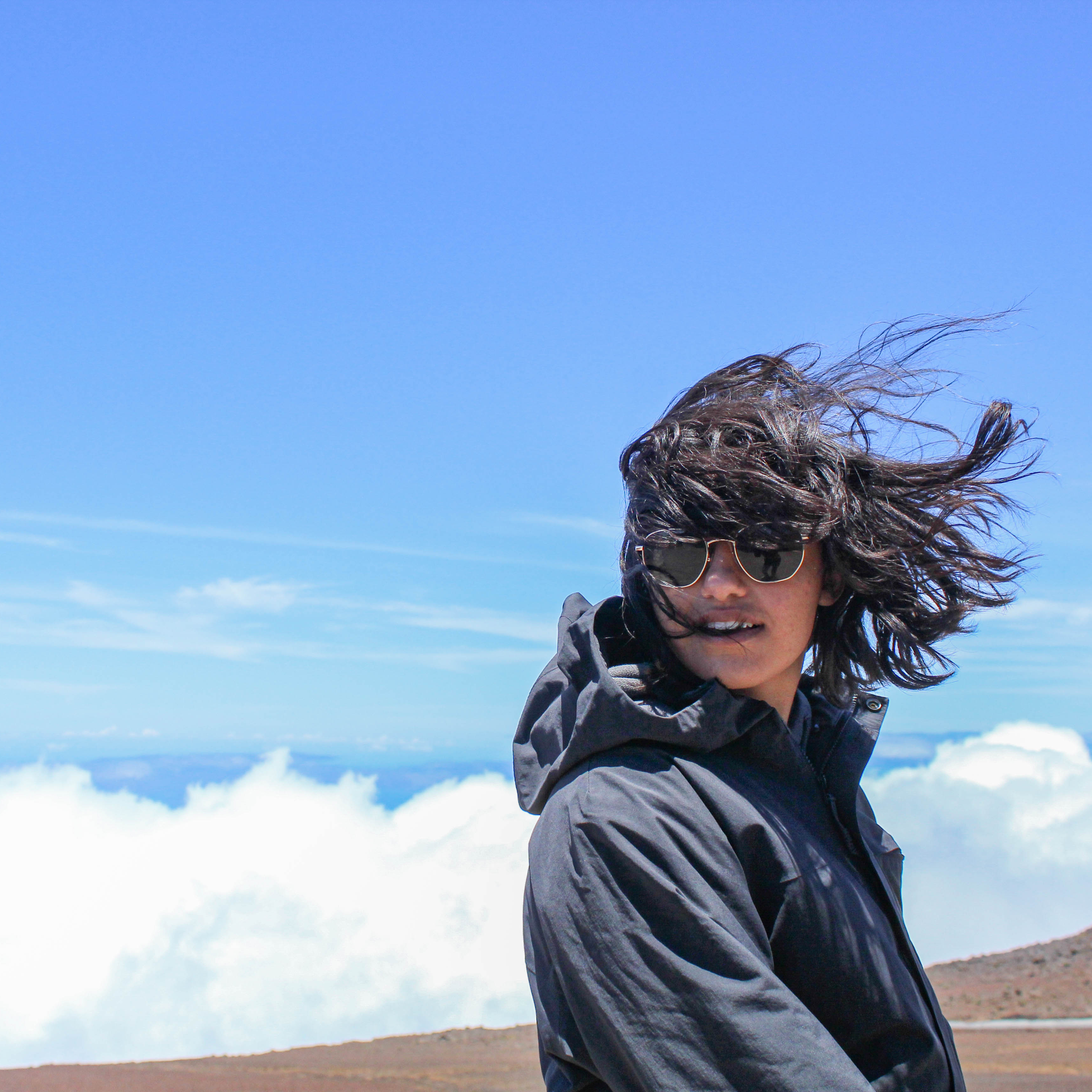 Image of a girl with clouds behind her.