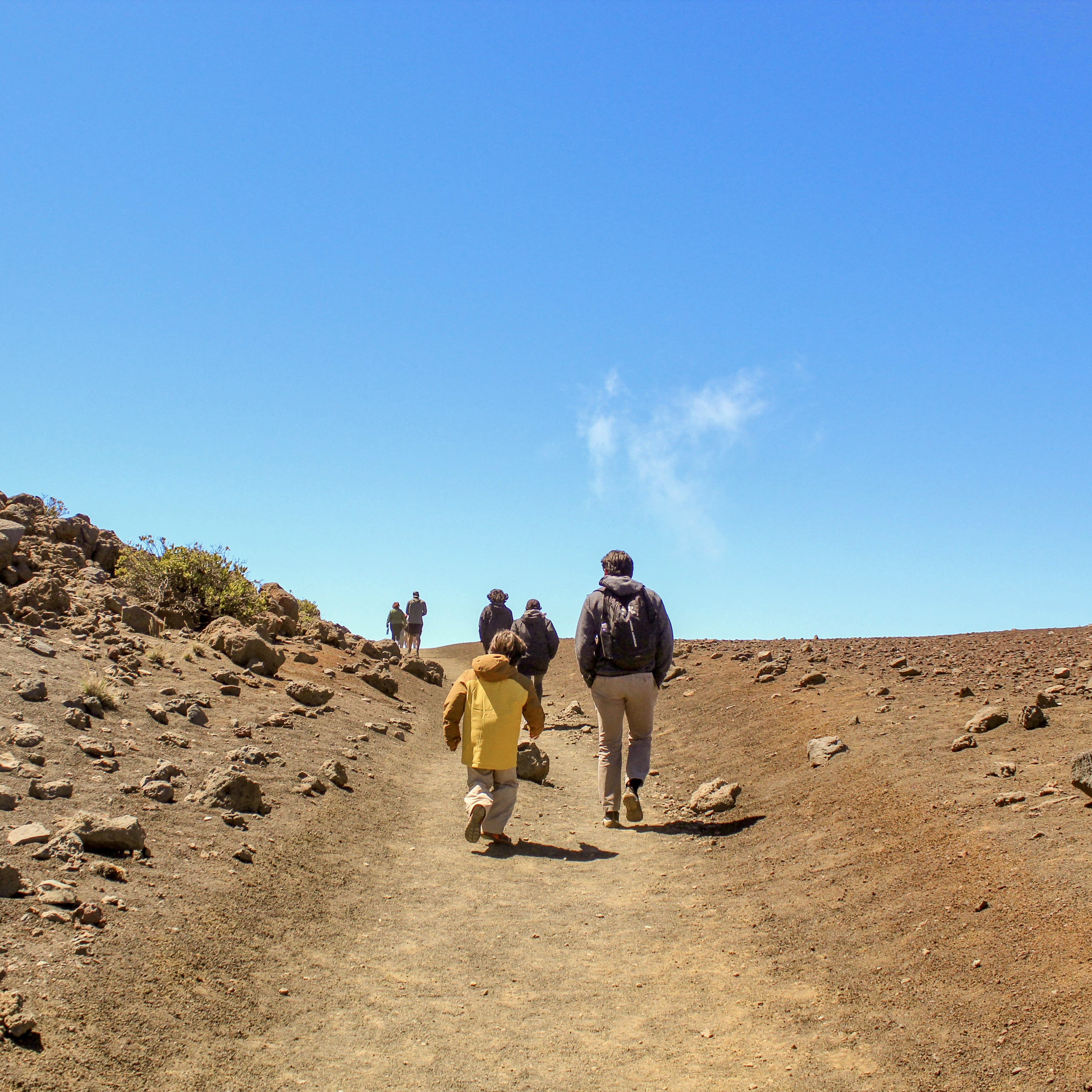 Image of two people walking down a dirt path.