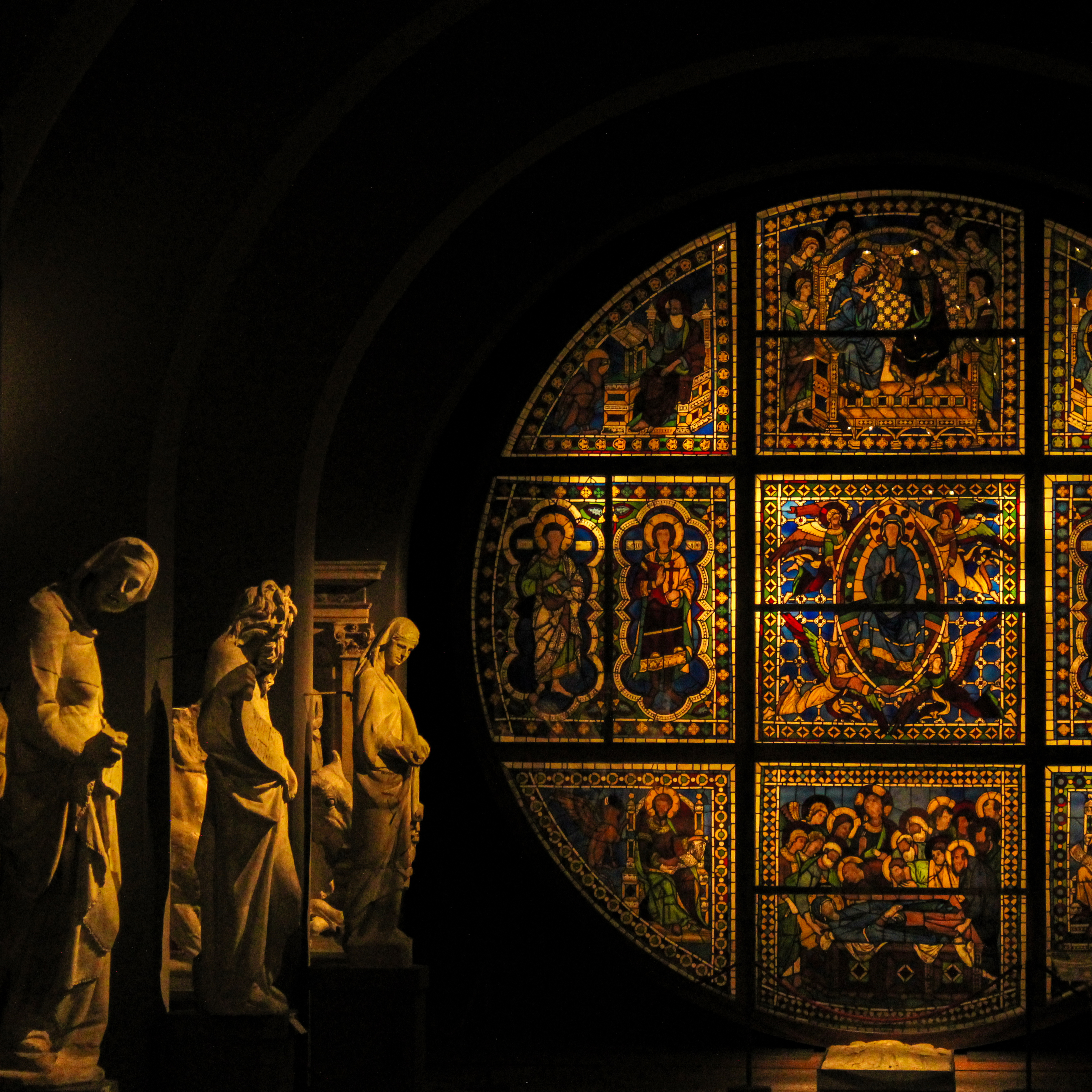 Image of sculptures with stained glass to the right.